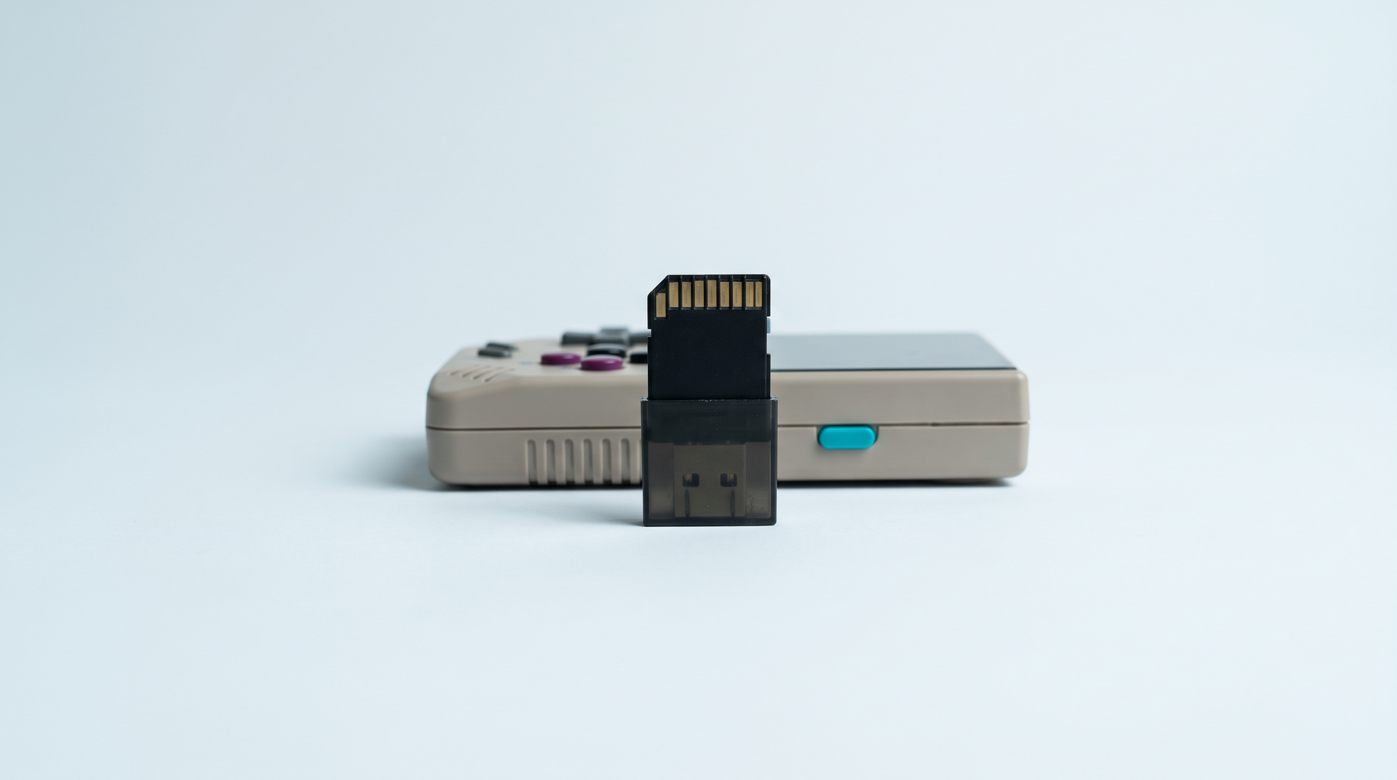 Carte microSD dressée dans un lecteur USB, console portable rétro compacte posée derrière