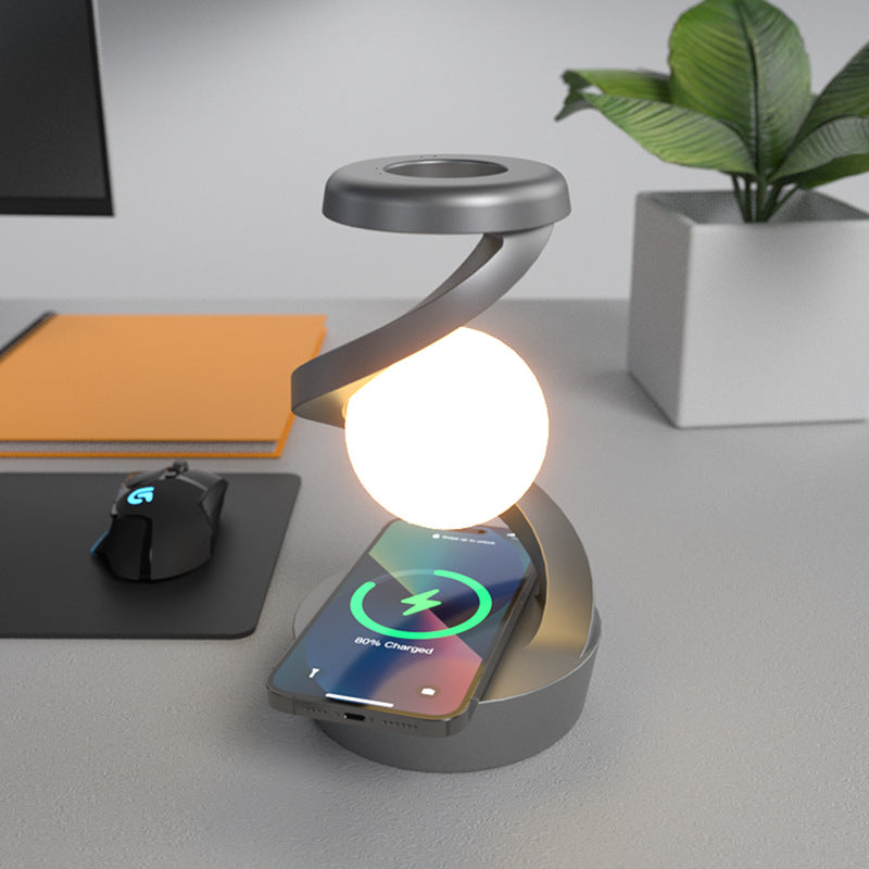 Lampe de chevet à sphère lumineuse, coloris gris, avec un téléphone en charge sur le socle