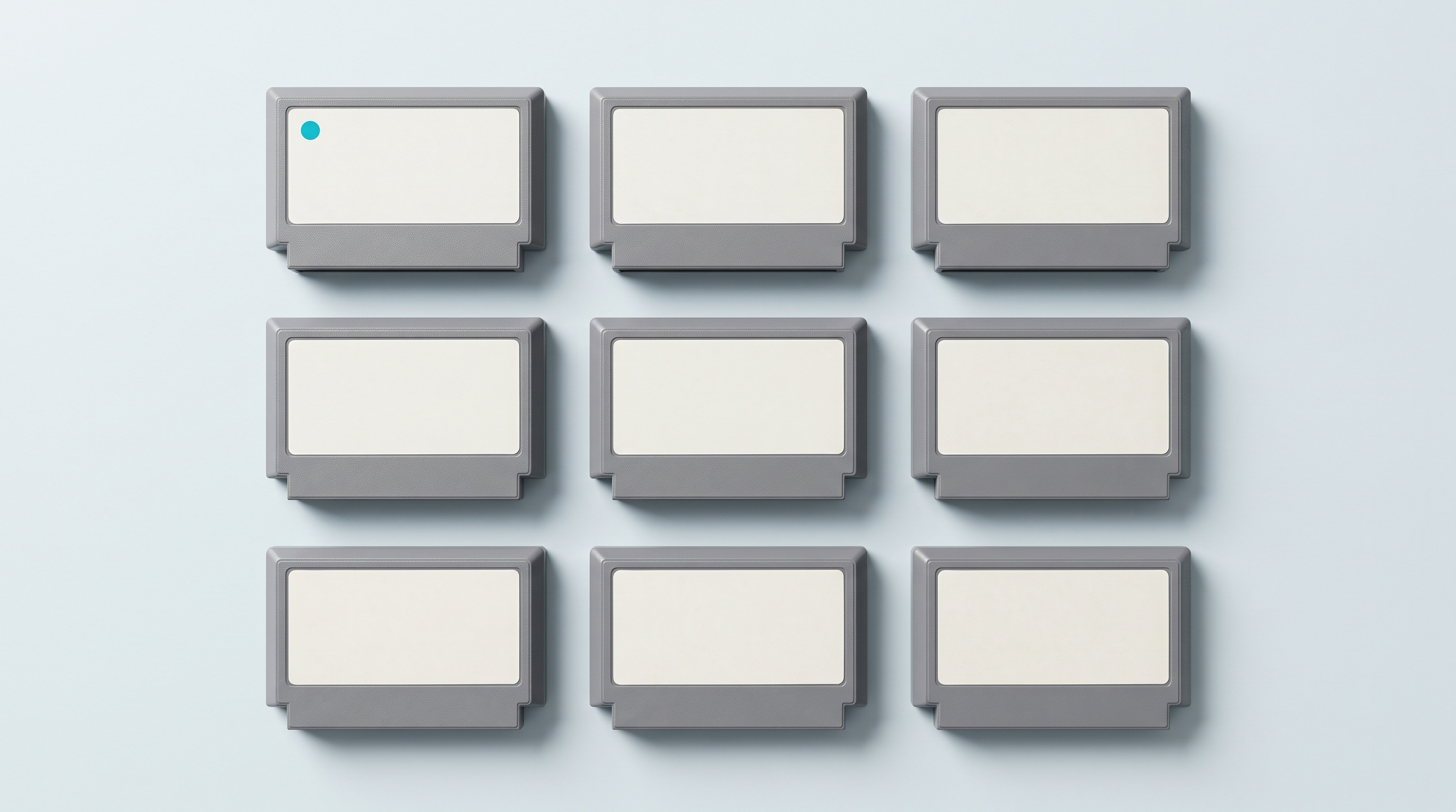 Neuf cartouches de jeu à étiquette vierge rangées en grille de trois sur trois, vues du dessus