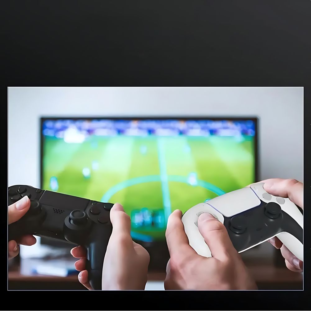 Two gamers holding PS5 and PS4 controllers while playing a soccer game on TV