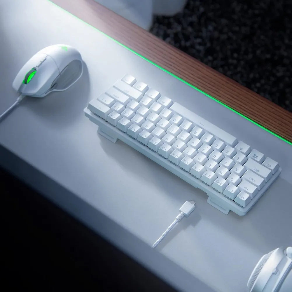 Futuristic white gaming keyboard and mouse on a sleek desk with RGB lighting.